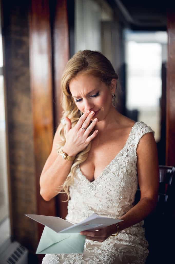 bride reading card from groom on wedding day
