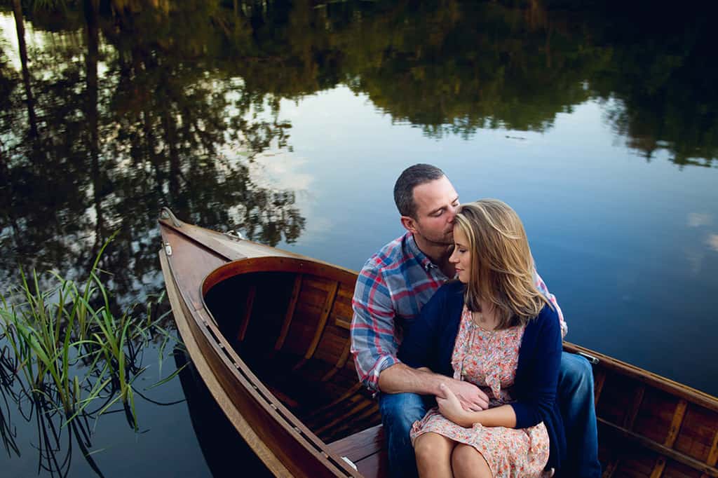 engagement session with wooden boat on lake
