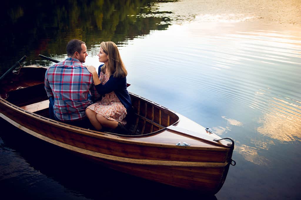 engagement session with wooden boat on lake