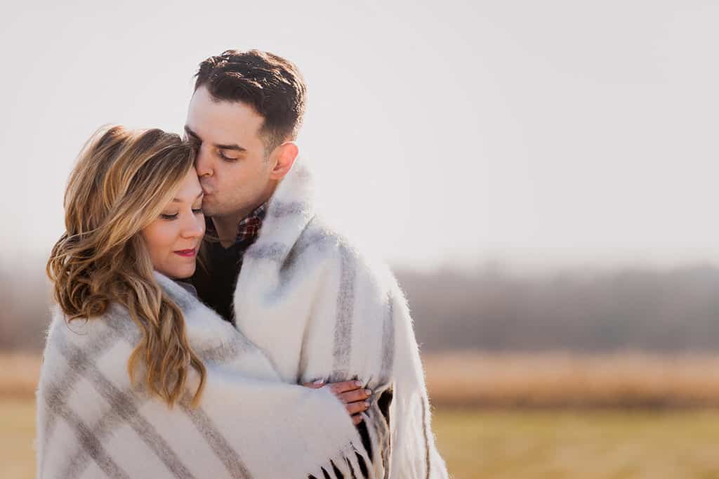 romantic engagement photo couple wrapped in blanket