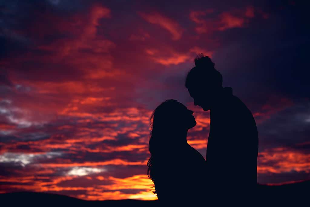 engaged couple's silhouette against winter sunset