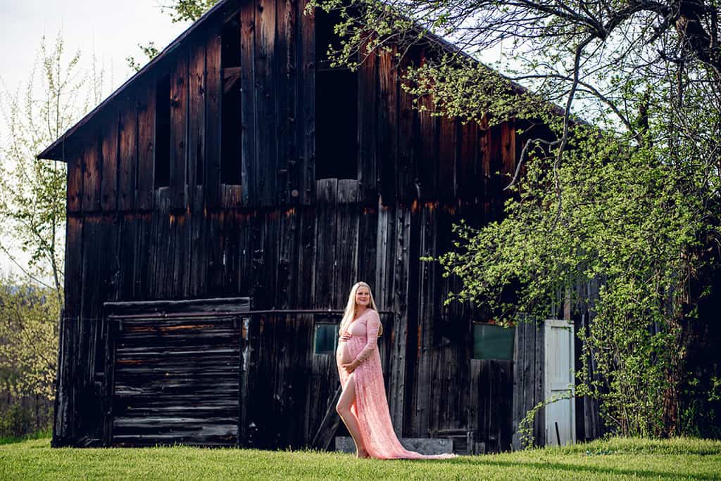 Spring maternity shoot with ethereal pink lace maternity dress at a rustic barn
