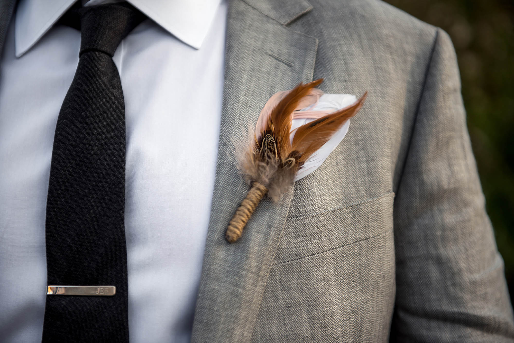 groom's feather boutonniere at boho hunter mountain wedding