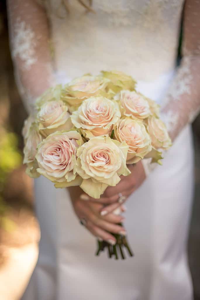 bride holding white rose bouquet 