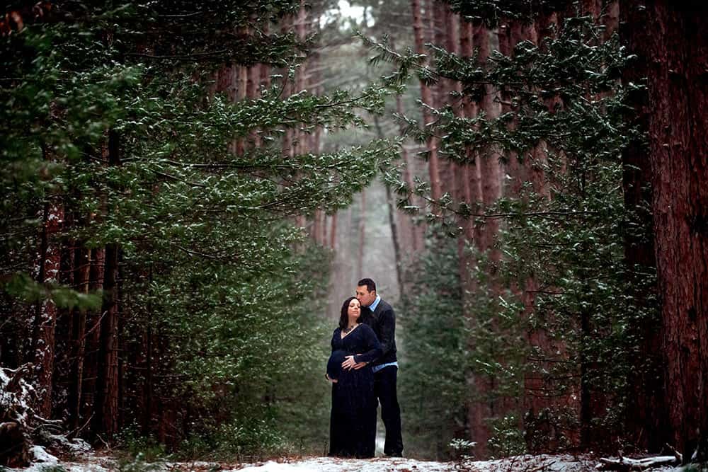 Winter Maternity Session in Pine Forest with Navy Blue Maternity Gown